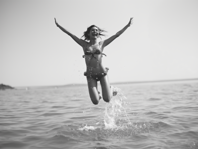 Joyful woman jumping out of water