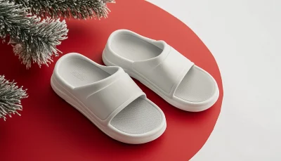 Pair of Modern Yeezy White Sliders on Red Christmas Background