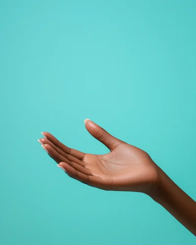 Dark Skinned African Woman’s Hand on Mint Blue Background